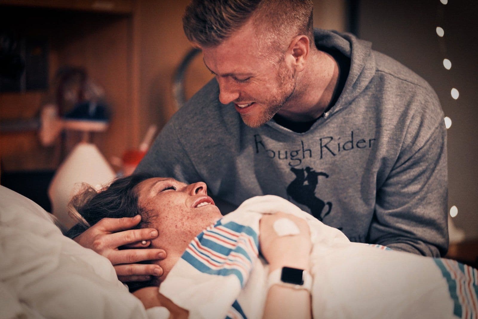 A birth partner supporting a laboring mother, offering encouragement and physical comfort