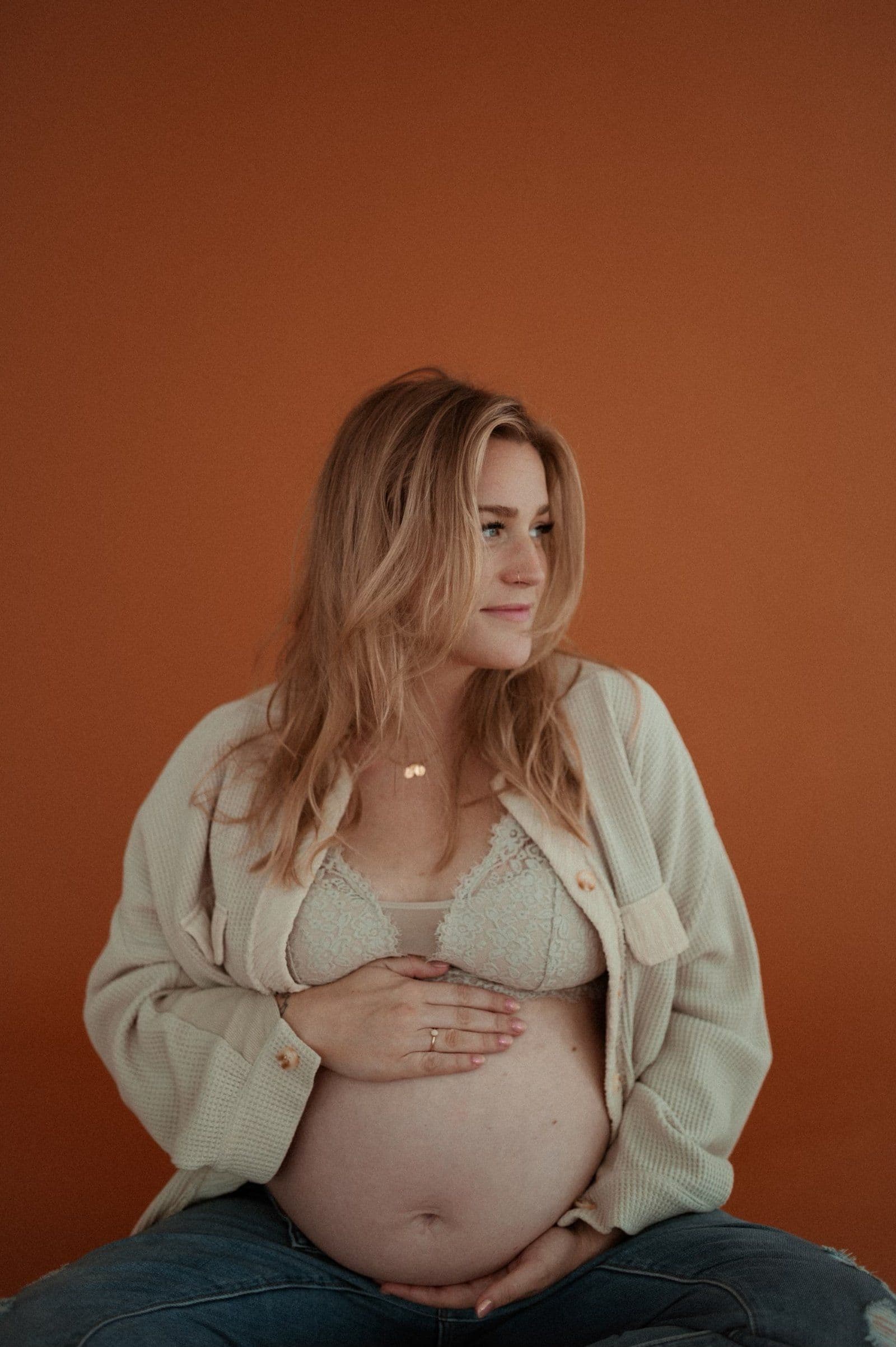 A pregnant person sitting calmly with eyes closed, practicing deep breathing